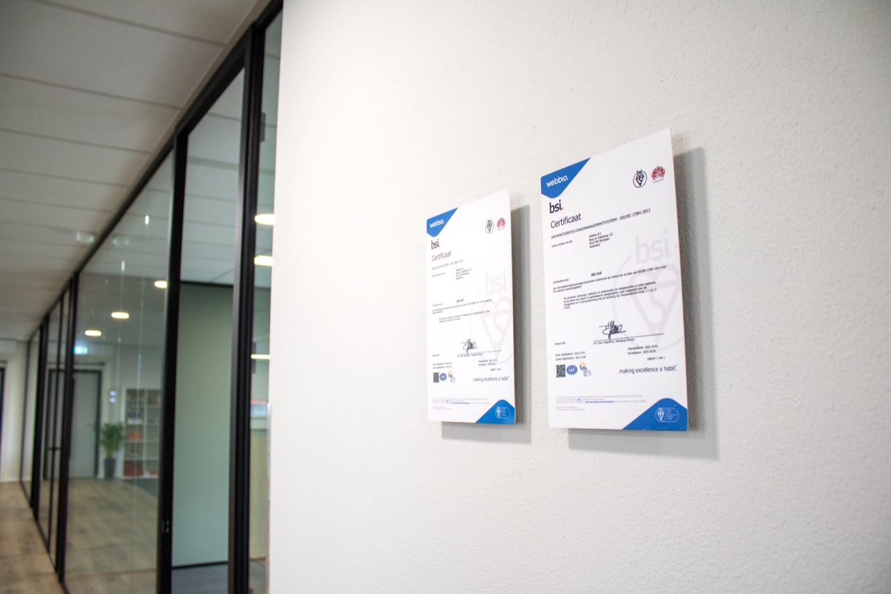 Webbio developer werkt geconcentreerd achter een bureau bij het raam